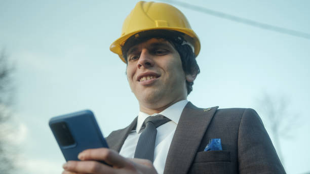 Modern Business and Shopping: A Young Entrepreneur or Civil Engineer Using a Smartphone for Online Purchases