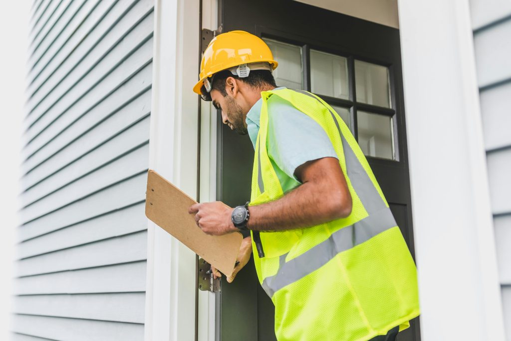 Contractor inspectiung door to a house.