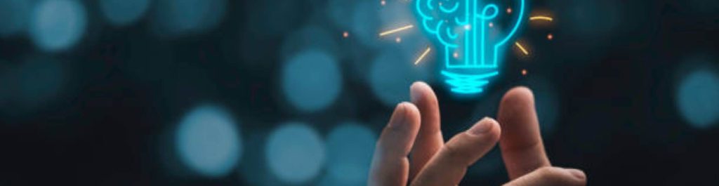 hand holding a lightbulb with half of it a brain