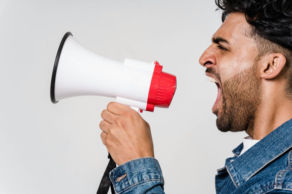 man yelling into speaker